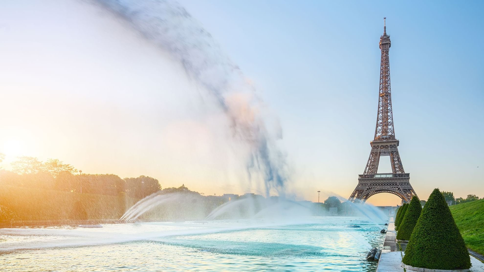 Eiffel Tower at sunrise, surrounded by water fountains, near Warwick Hotels and Resorts