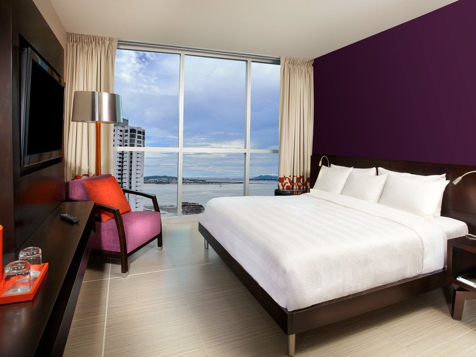 Comfy bed with TV in Junior King Ocean View at Megapolis Hotel Panama