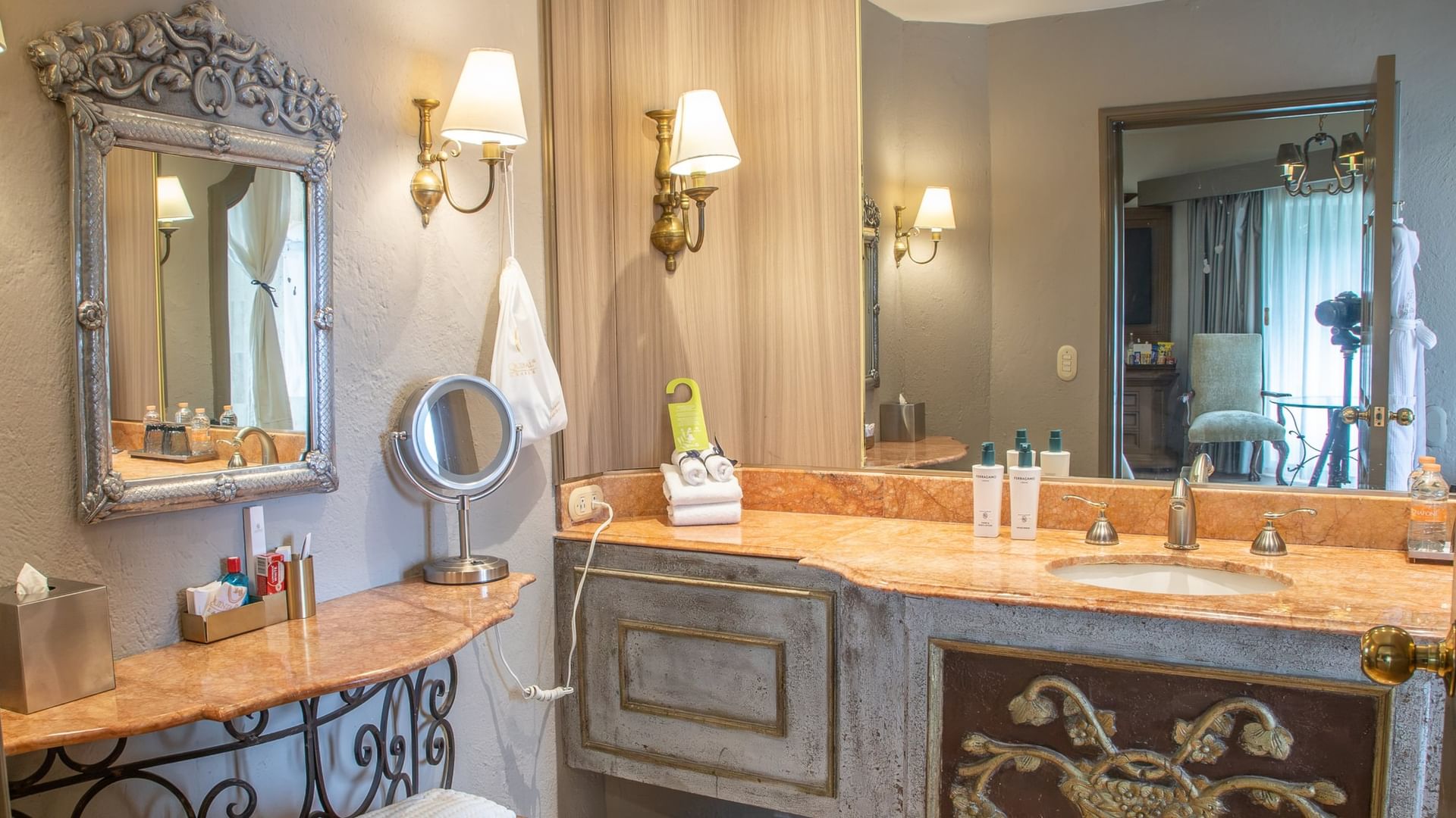 Elegant bathroom with ornate mirror, marble vanity, wall sconces, and decorative details at Quinta Real Guadalajara