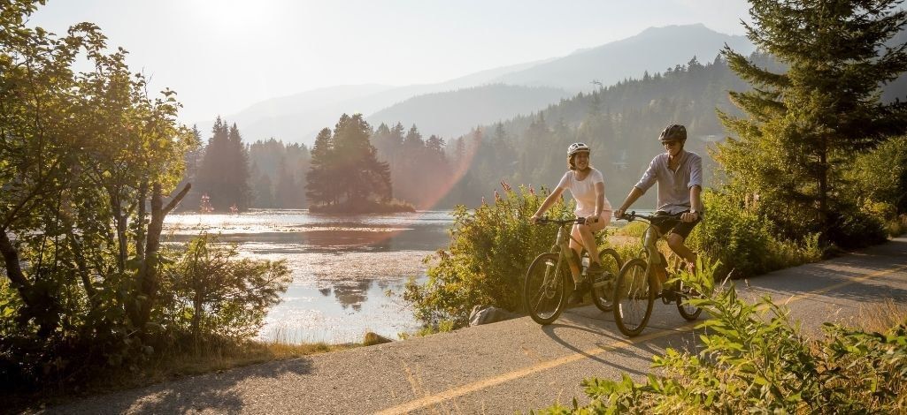 Cyclists riding along a lakeside trail in Whistler