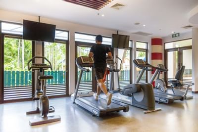 Man running on a treadmill in the gym at Paradox Phuket Resort
