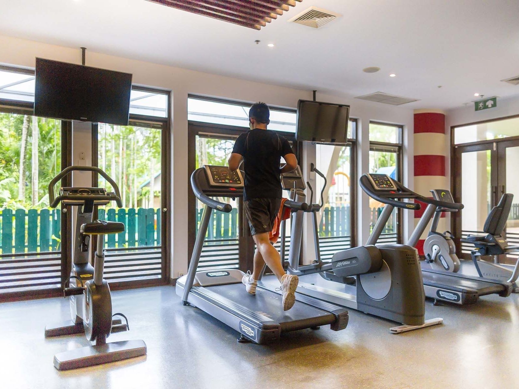 Man running on a treadmill in the gym at Paradox Phuket Resort