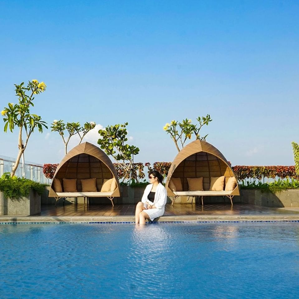 Woman relaxing on pool deck with comfy cabanas at LK Hospitality Group