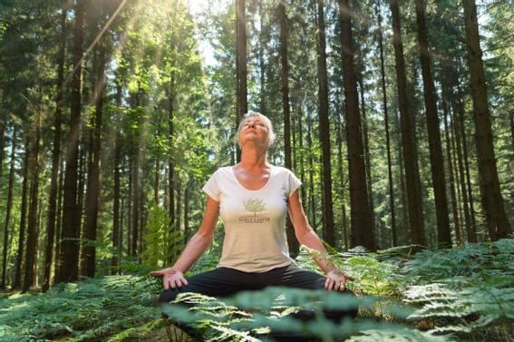 Woman meditating in a forest near Honor’s Haven Retreat