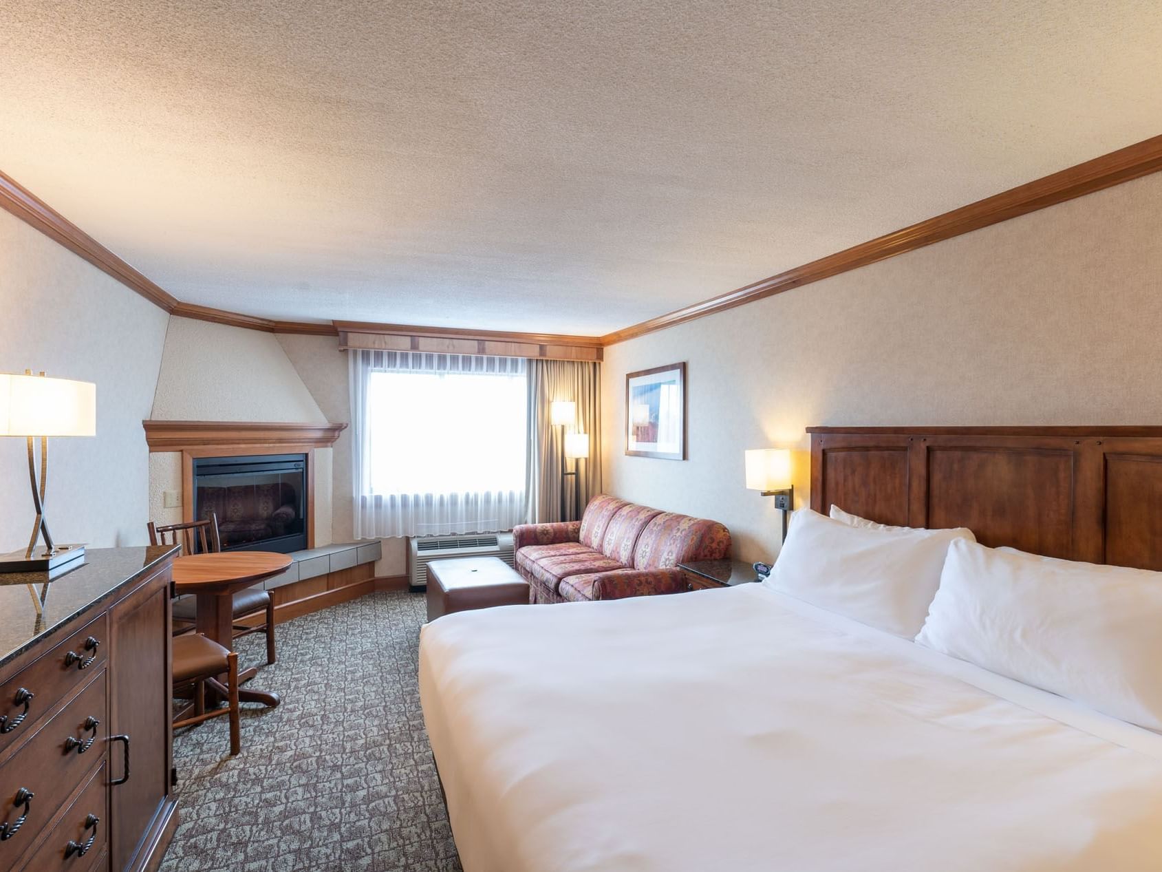 King room with a comfortable bed, couch, and a balcony at Lake Placid Club Grandview