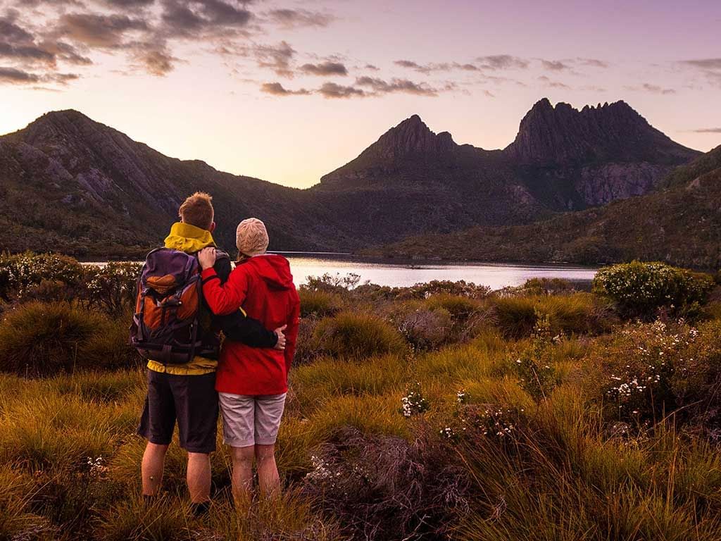 Couple overlooking the mountains & lake from a viewpoint near Cradle Mountain Hotel