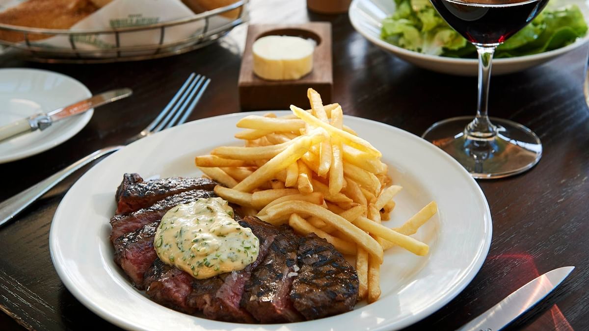 Grilled steak with fries on a plate in Bistro Guillaume at Crown Hotel Melbourne
