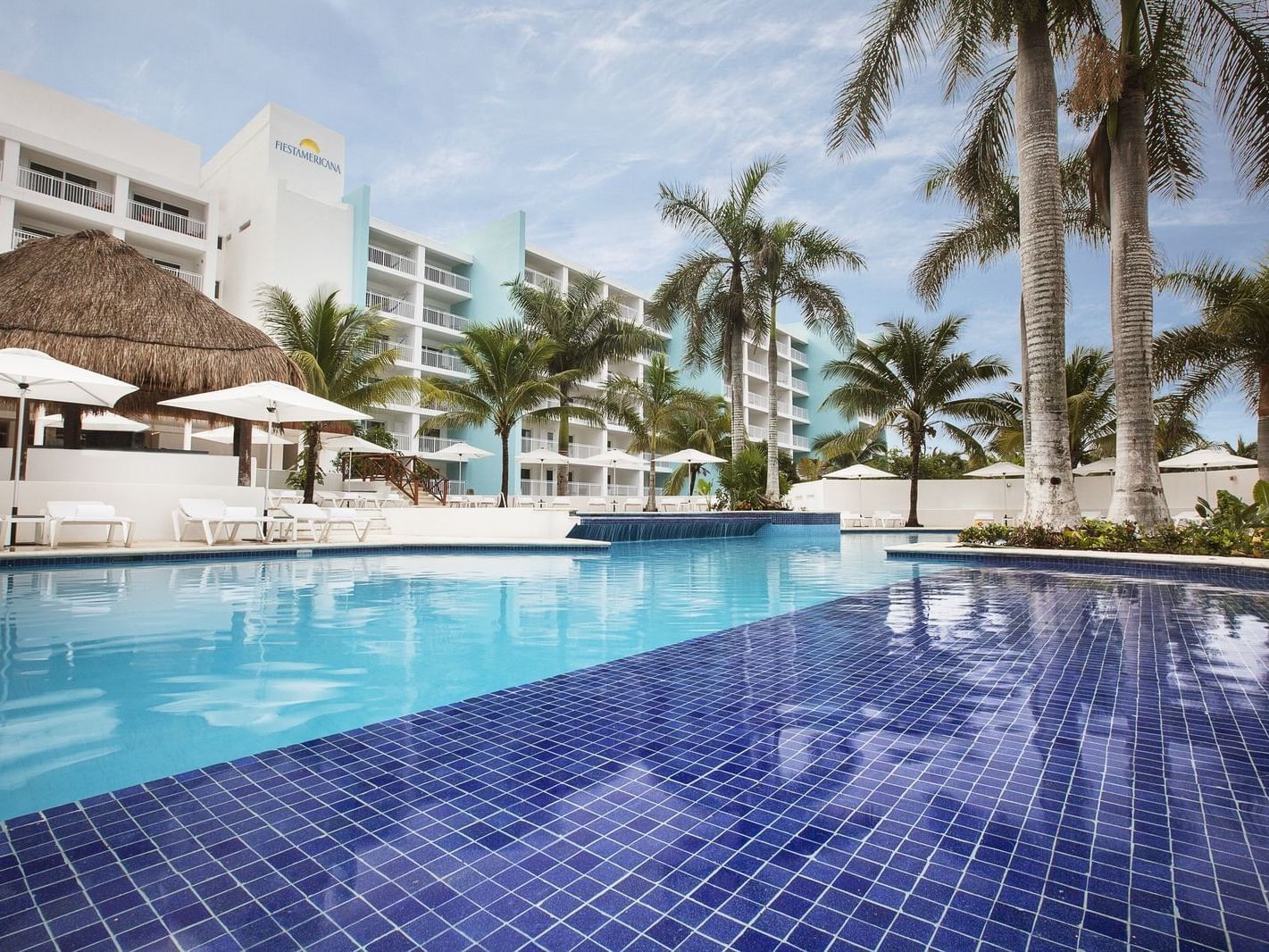 Outdoor pool & palm trees around it at La Colección Resorts