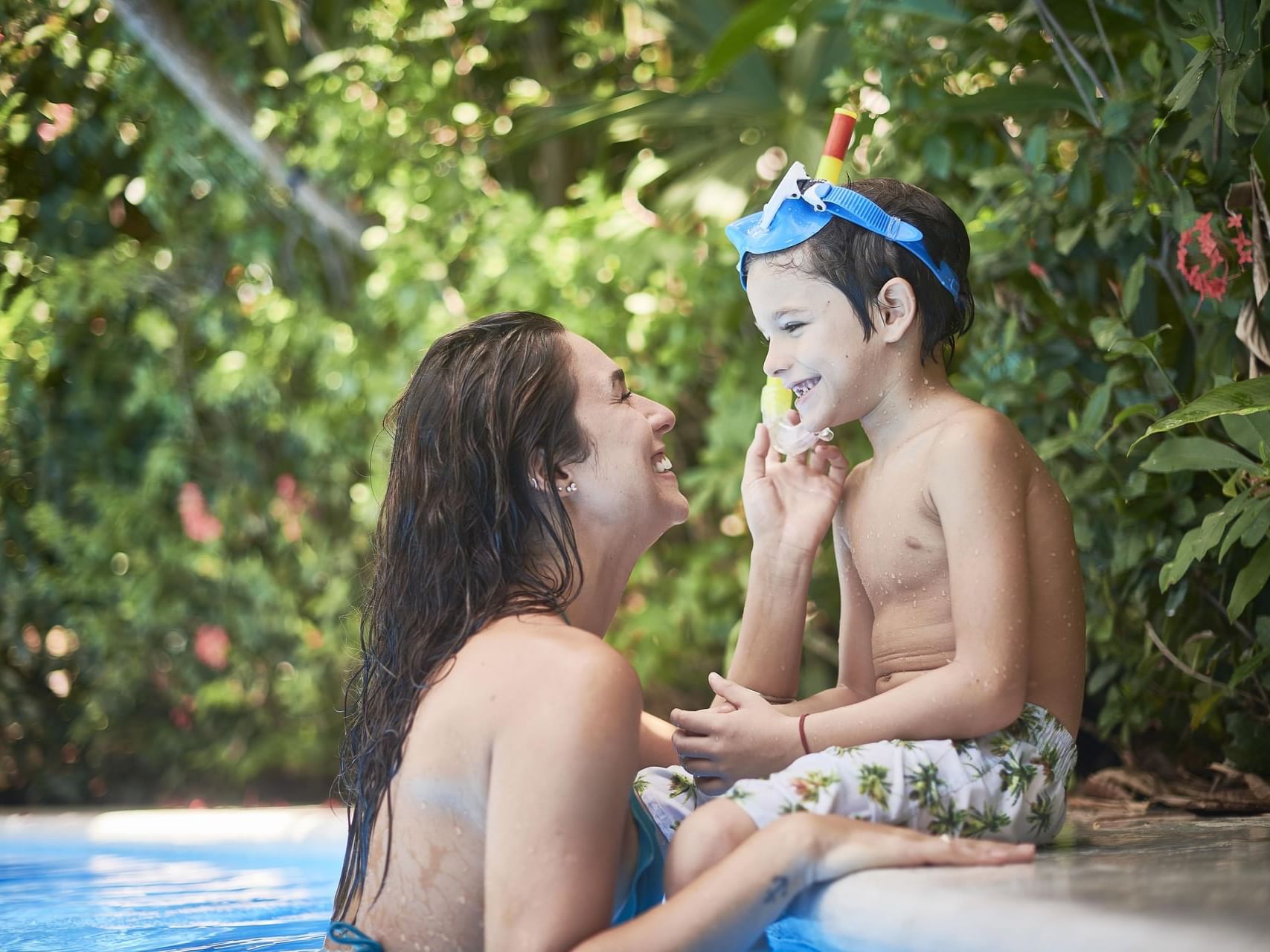 A kid and woman playing in the pool at Cala Luna Boutique Hotel