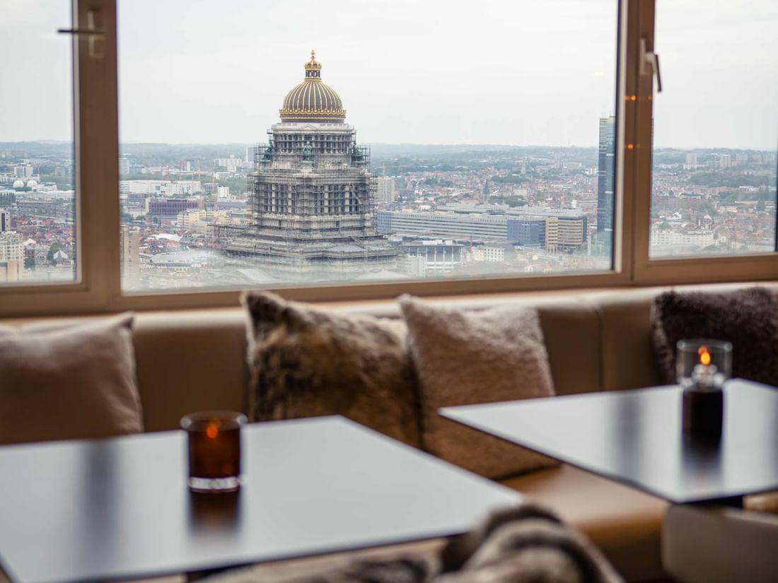 Panorama Lounge with comfortable seating by the window offering city views at The Hotel Brussels