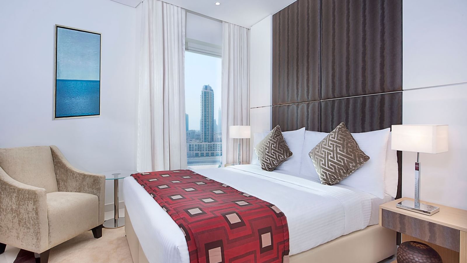 Room interior with queen bed and bedside lamp in Two Bedroom Suite at DAMAC Maison Canal Views