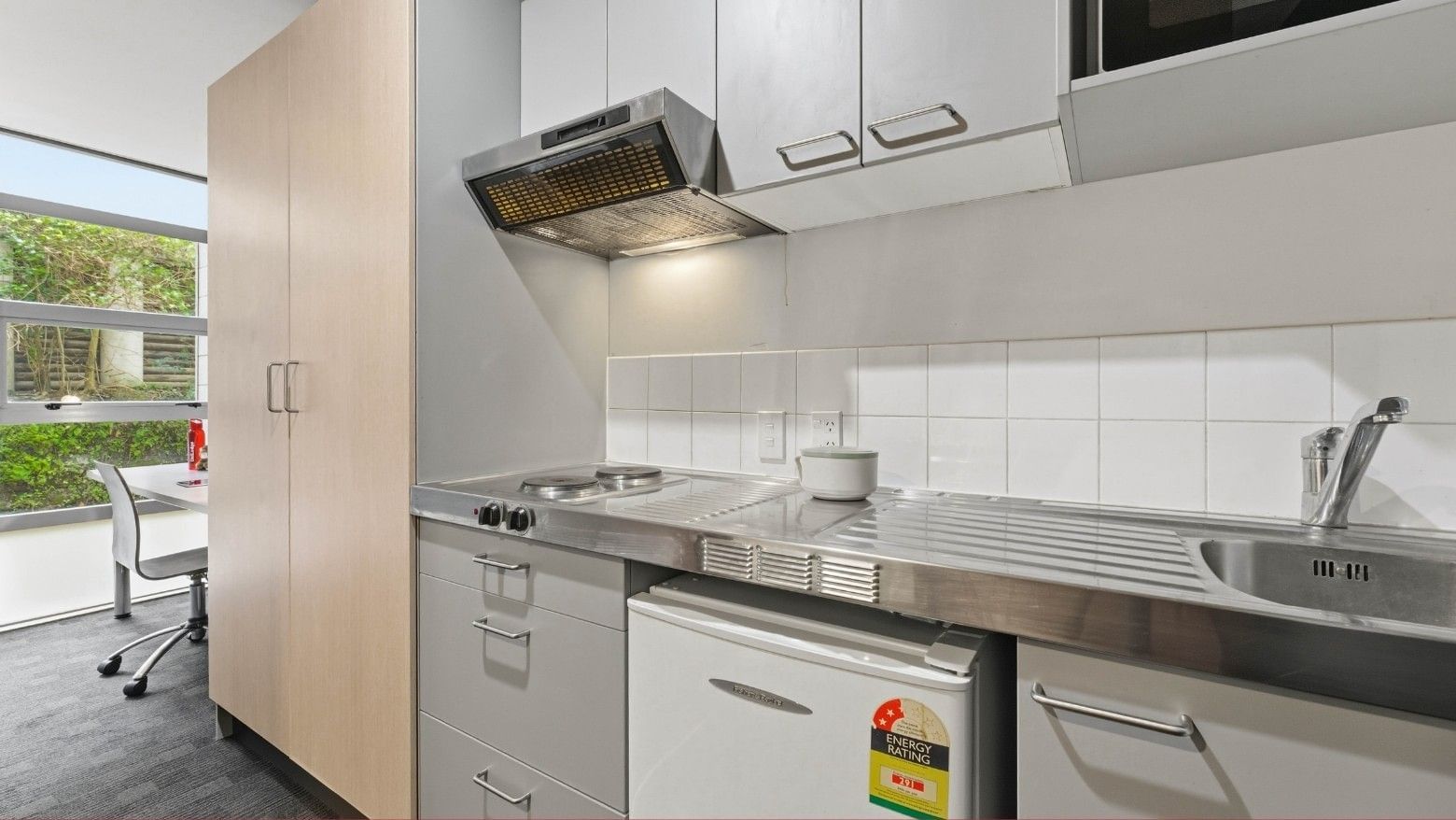 Modern kitchen with stove, sink, and refrigerator at Student Living Auckland - Beach.