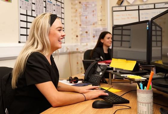 A receptionist working with her computer at Richmond Hill Hotel