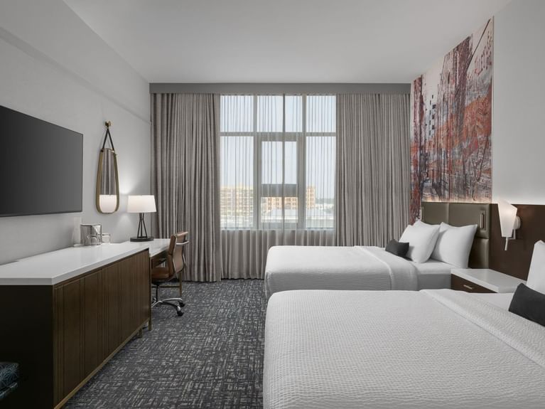 Capitol Double Queen room with an accent wall mural of a brown cityscape and a beautiful window view at Hotel 43 Boise
