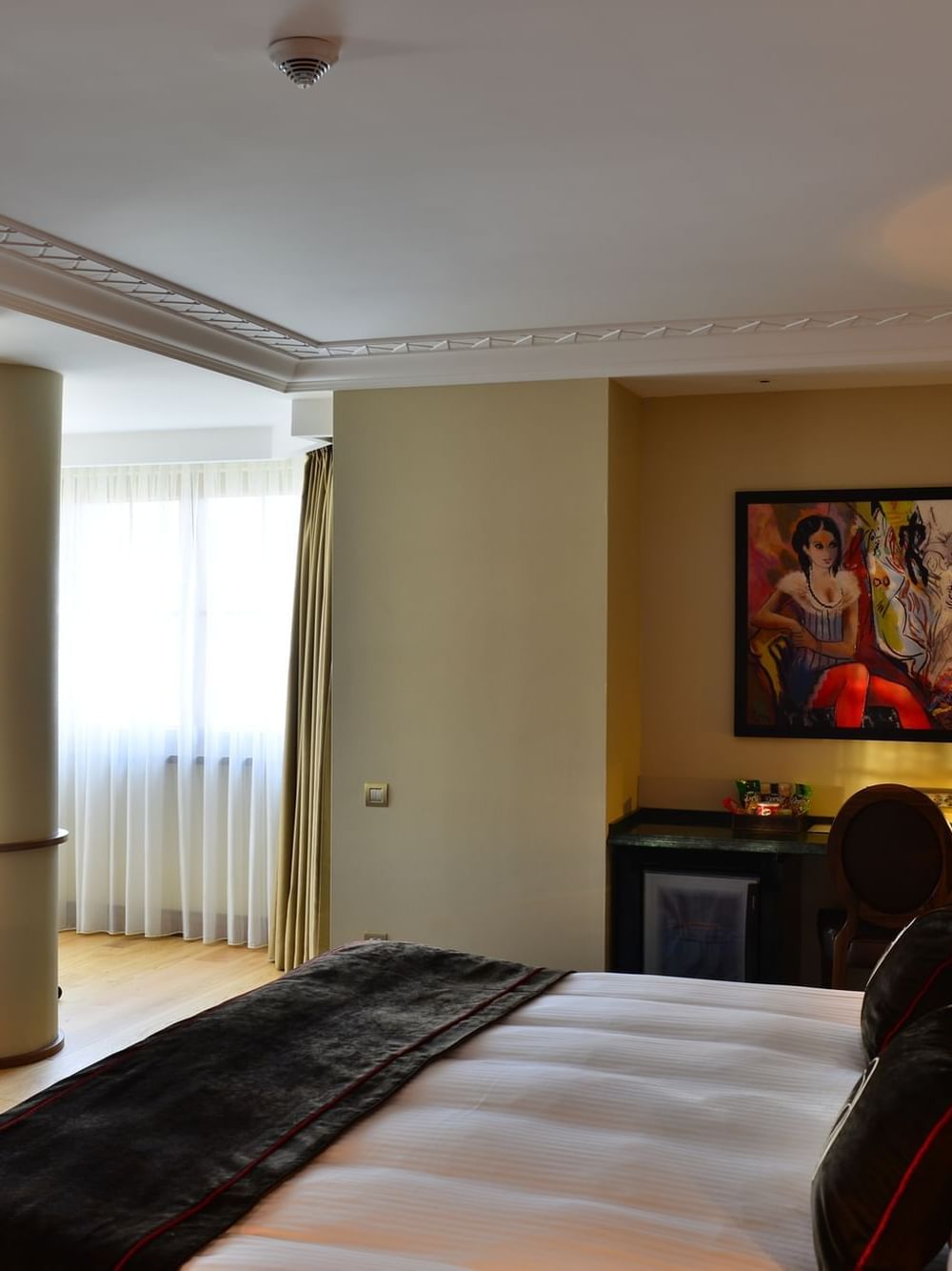Large TV by a bed with plush pillows under a white ceiling in Executive room at Warwick Ankara