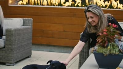 A lady petting a dog in the patio at The Nest Palo Alto