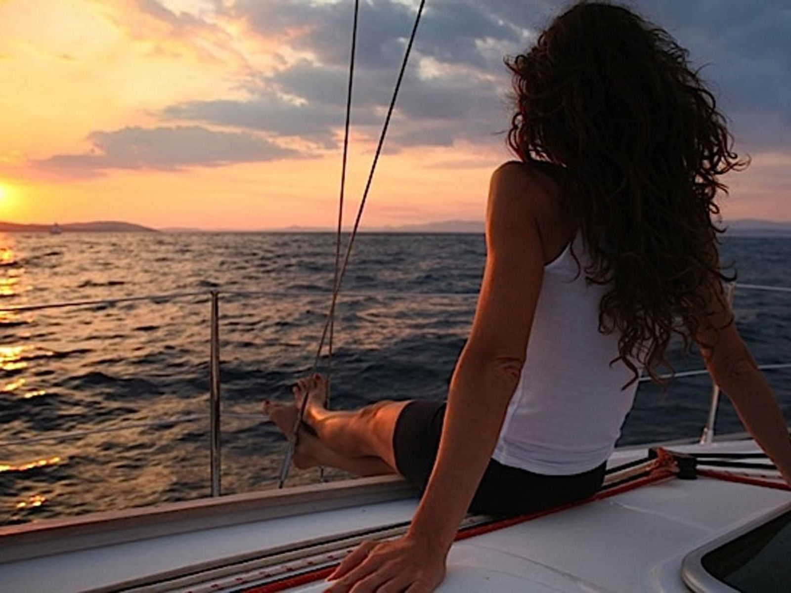 Uma menina a relaxar no convés de um barco no meio do mar