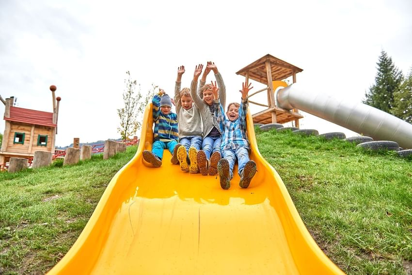 3 kids enjoying a sliding board at Liebes Rot Flüh.