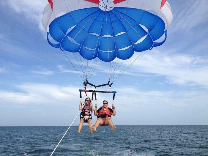 Two people parasailing over the ocean near Los Altos Resort