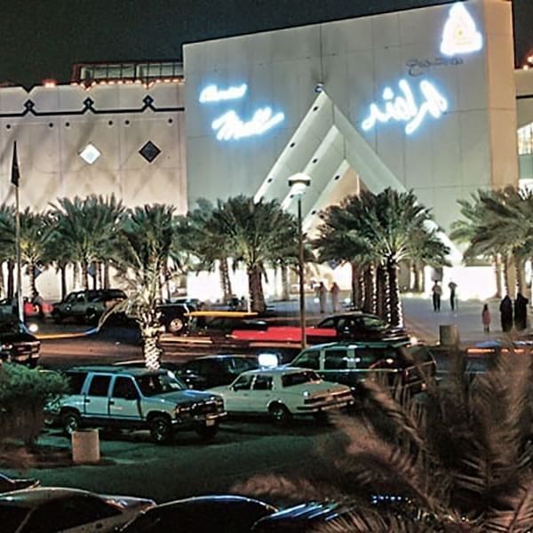 Al Rashid Mall by palm trees under a night sky, surrounding a busy parking area near Naviti by Warwick Al Khobar