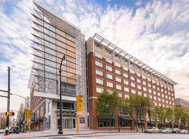 A large building with a glass and brick exterior, seen from across the street.