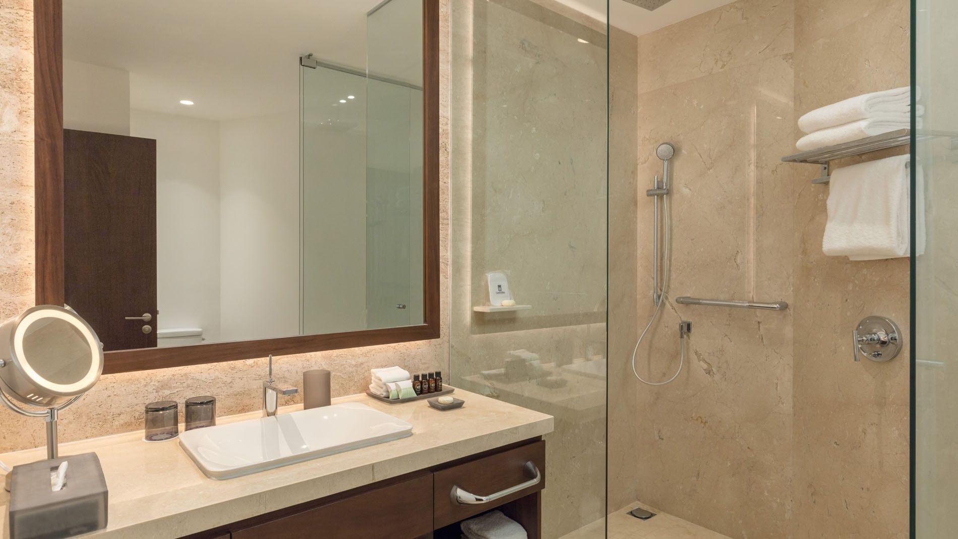 King Camino Real Club walk-in shower with beige marble tiles, sleek fixtures, and a vanity mirror at Camino Real Merida