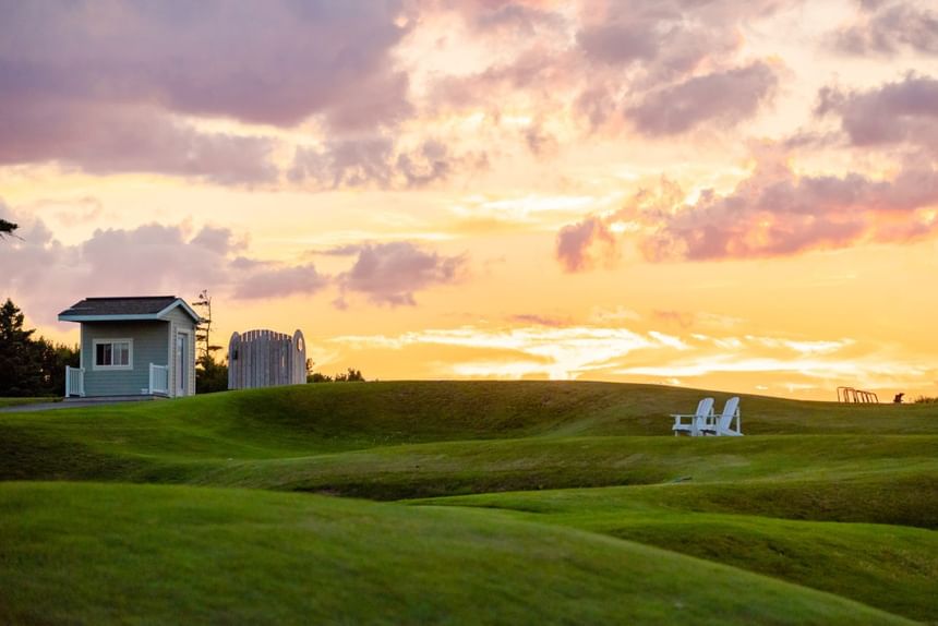 Sunset over green fairways and lawn chairs right by the popular Crowbush Golf Resort at Rodd Crowbush Golf & Beach Resort