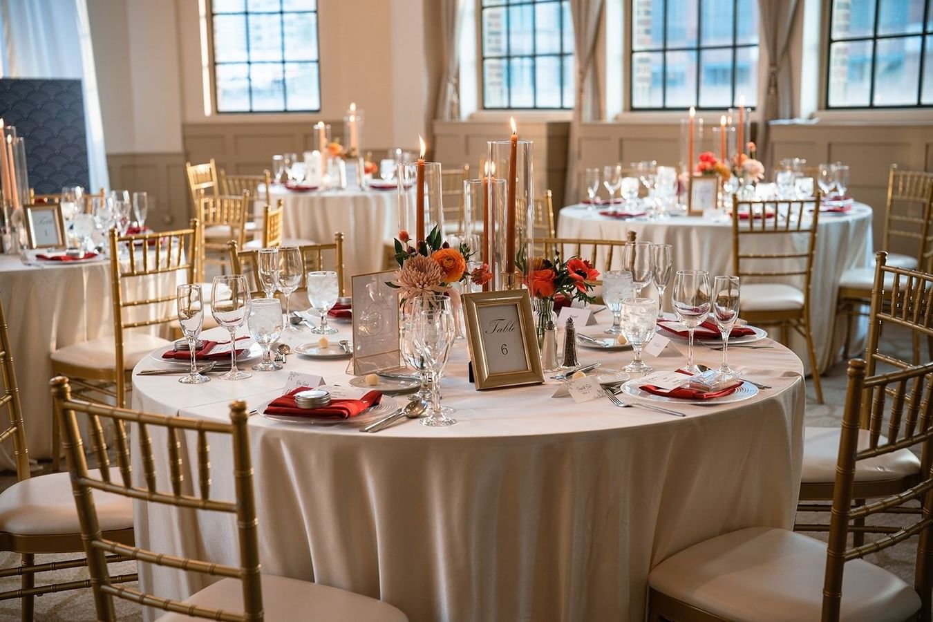 Elegantly set dining tables with gold chairs and floral centerpieces at Warwick Allerton Chicago