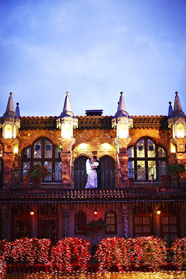 exterior of Mission Inn Hotel with bride and groom posing for pi