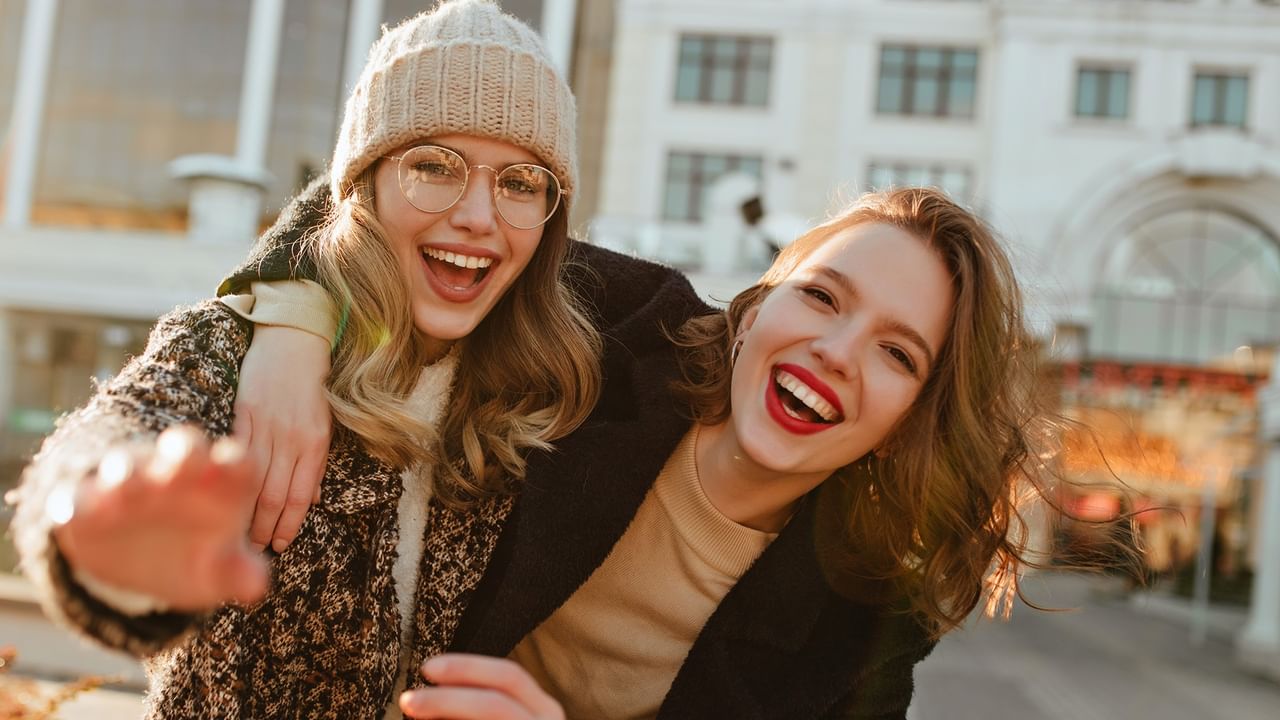 two women hugging wearing fall clothing