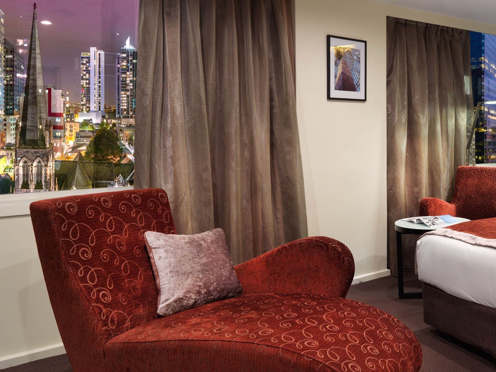 Chair by the window with a city view in Premier King at Hotel Grand Chancellor Melbourne