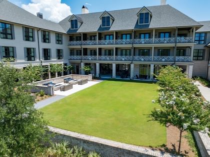 Manicured 1936 lawn surrounded by lush landscaping behind Camp Creek Inn in Inlet Beach.