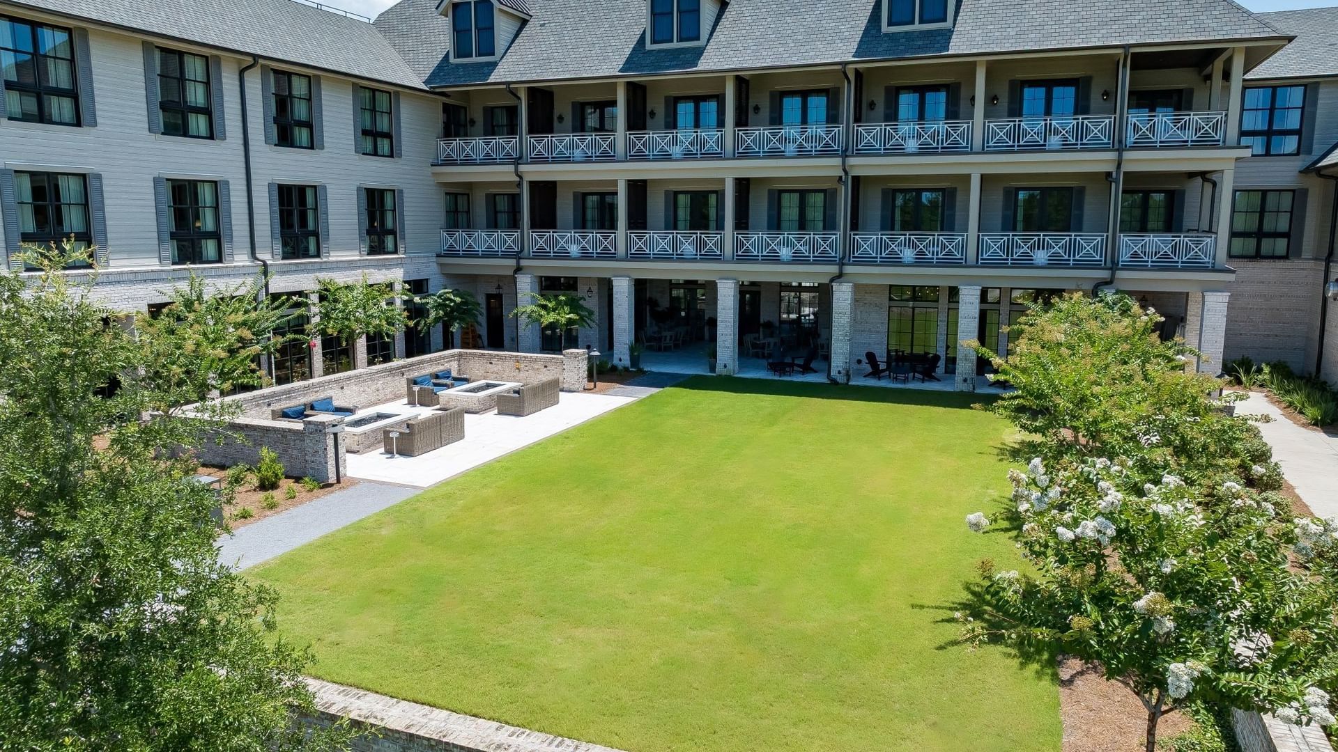 Manicured 1936 lawn surrounded by lush landscaping behind Camp Creek Inn in Inlet Beach.