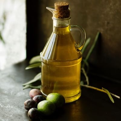 Close-up of olive oil bottle & olives at Falkensteiner Hotels