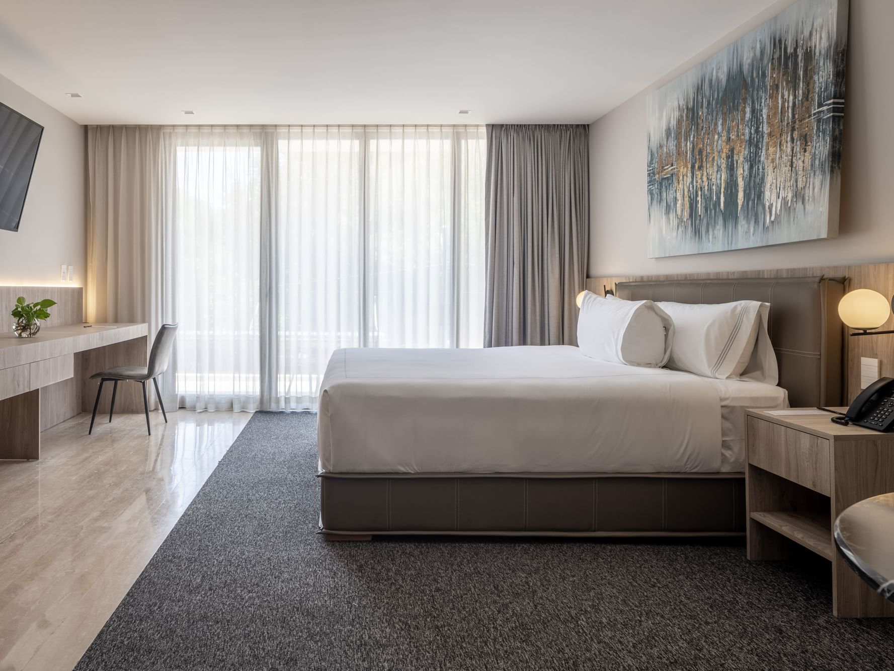 Cama grande con televisor y escritorio en Junior Suite de Elements by Marquis en Ciudad de México