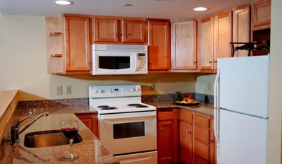 Kitchen area of The Suite at Pointe at Castle Hill featuring a oven, stove and a refrigerator