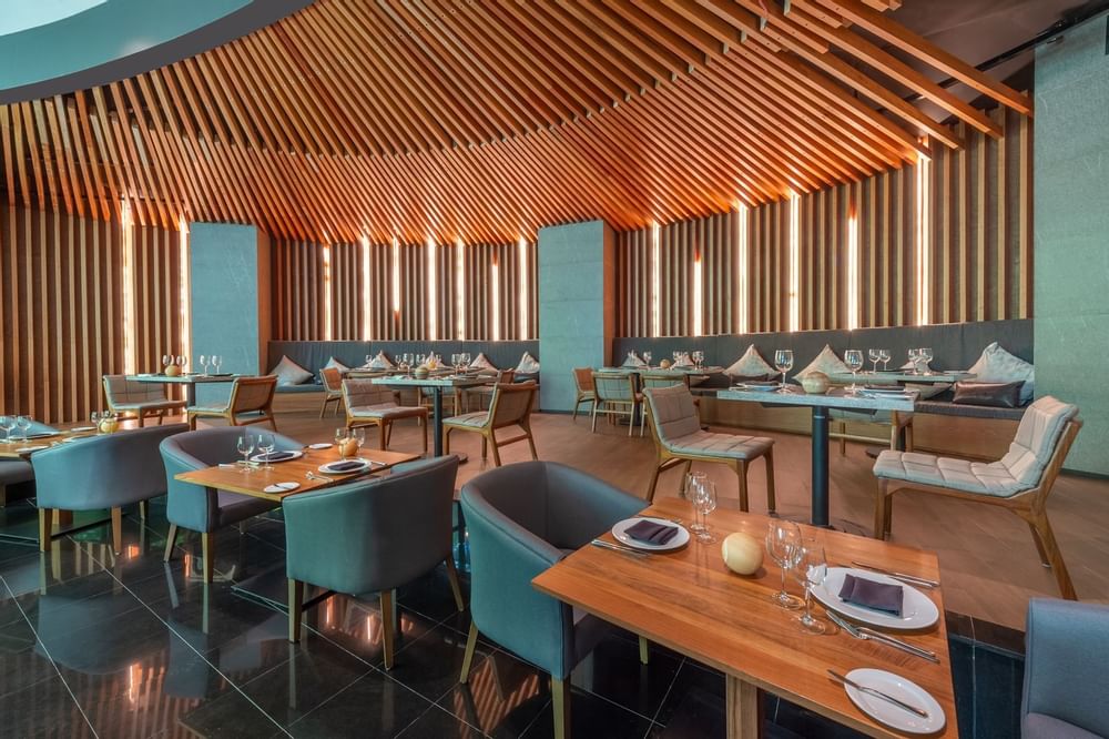 Dining tables arranged in a Restaurant at Live Aqua Resorts