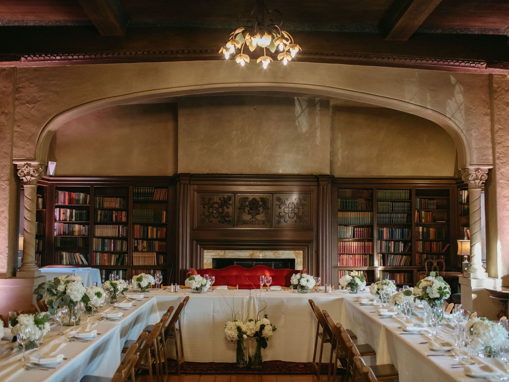 Members Lounge with bookshelves, fireplace & a table arranged at Berkeley City Club