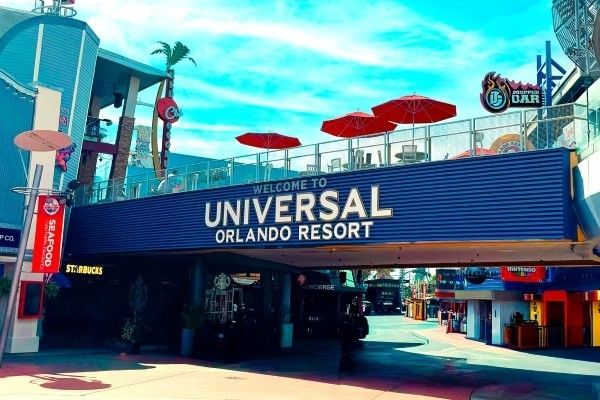 A large second story outdoor walkway with a white sign that reads Universal Orlando Resort at Universal CityWalk.