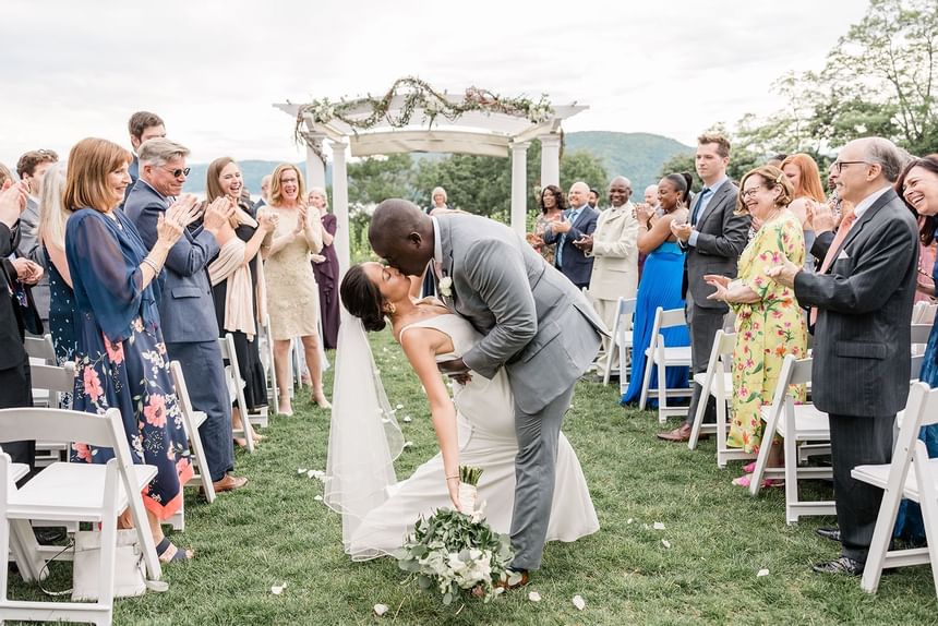 Newly weds kissing & guests cheering at The Abbey Inn