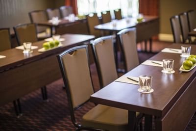 A modern conference room at The Paramount Hotel Seattle with brown tables and chairs set up for a meeting