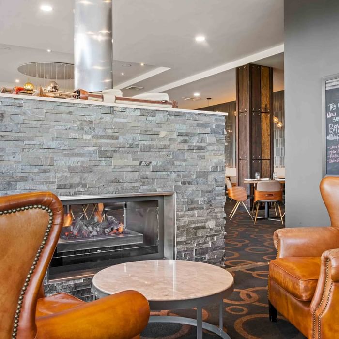 Wine Bar with a stone fireplace, leather chairs, and a chalkboard menu at Mercure Kooindah Waters