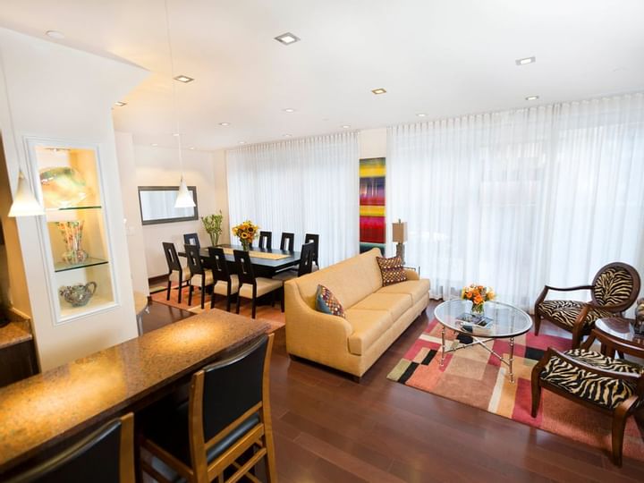 A wide view of a meeting room with a sofa, coffee table, dining table, and chairs