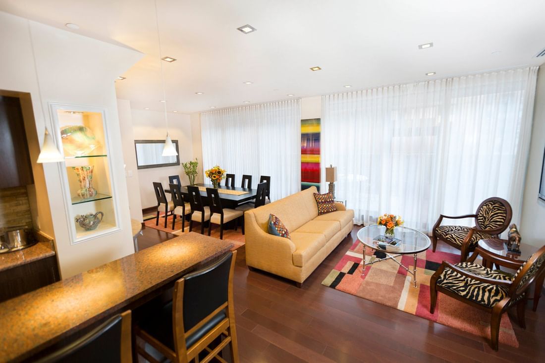 A wide view of a meeting room with a sofa, coffee table, dining table, and chairs