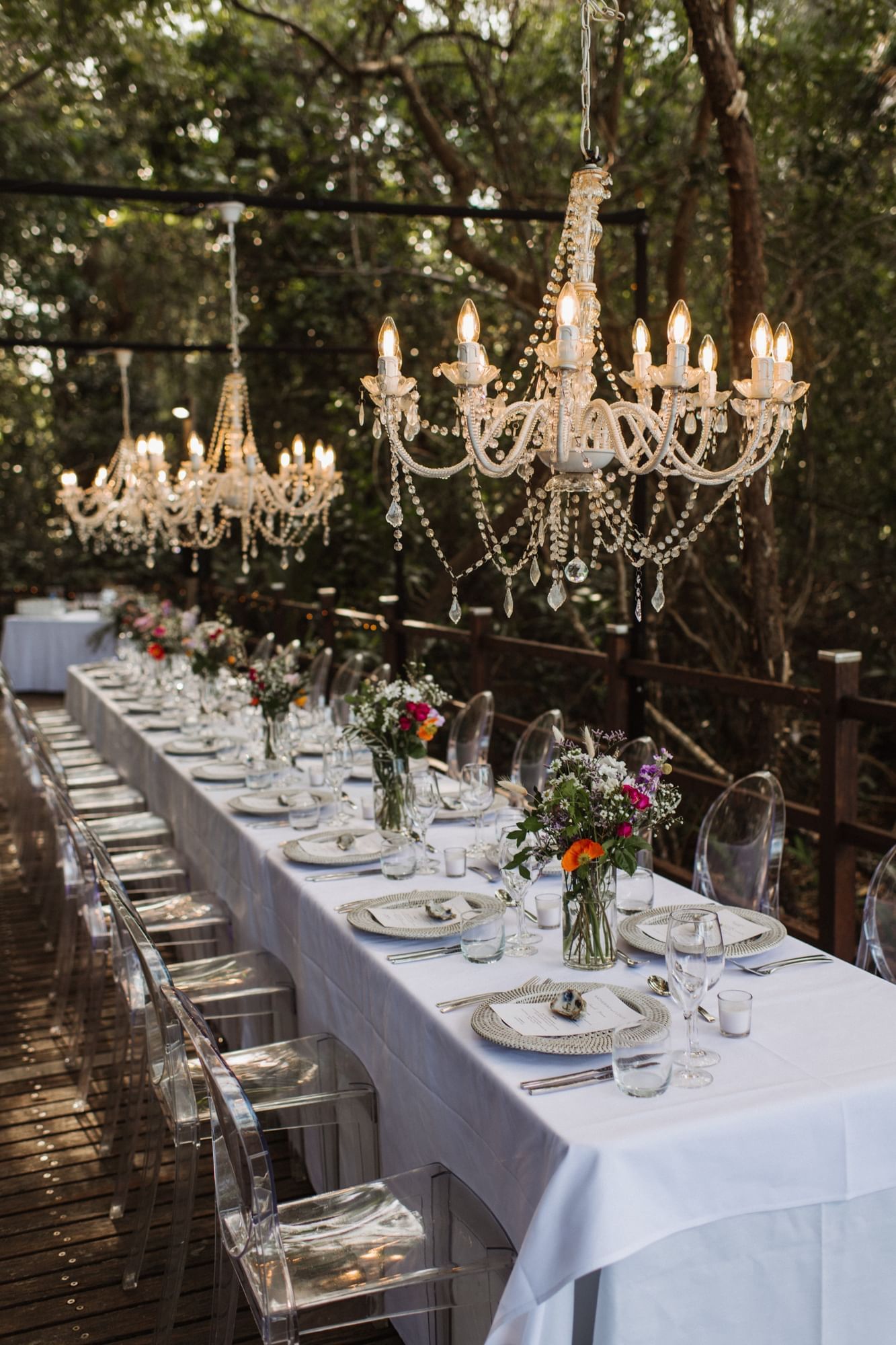 Outdoor dining setup with chandeliers & floral centerpieces in Boardwalk at Pullman Port Douglas Sea Temple Resort & Spa