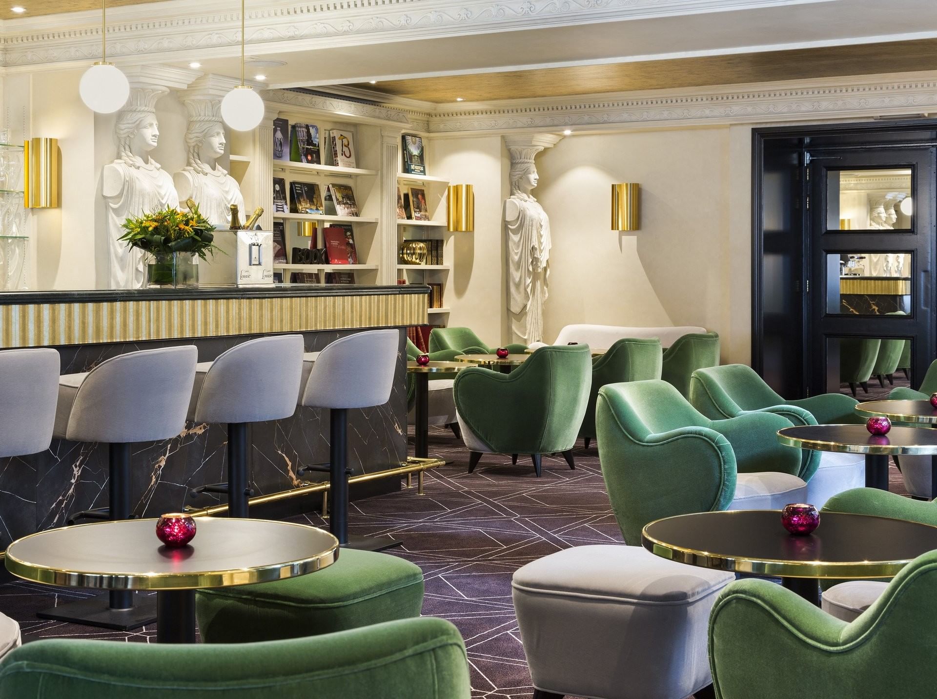 Stylish marble bar with green velvet seating and classic statues at Hotel Barsey by Warwick
