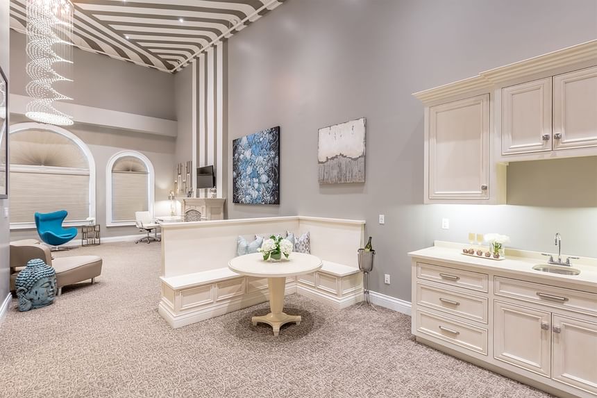 Kitchenette & living area with chandelier & comfy chairs in a Presidential Room at Retro Suites Hotel