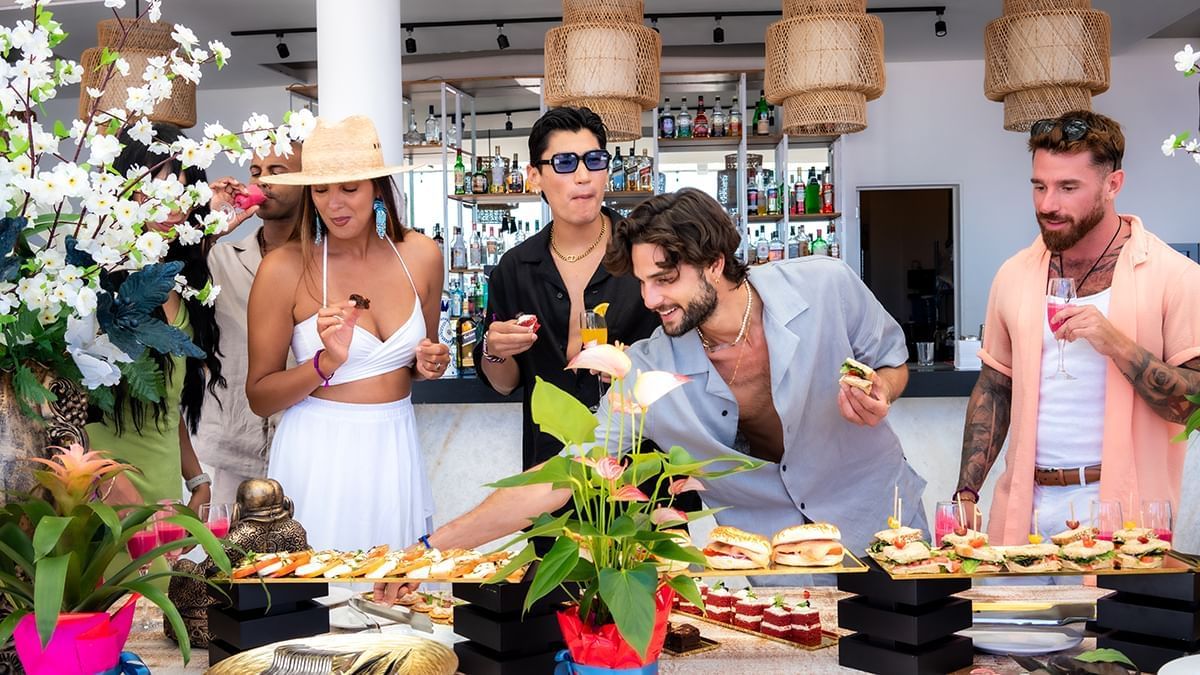 People enjoying the high tea buffet in The Top Sky Bar at Almar Beach Resort