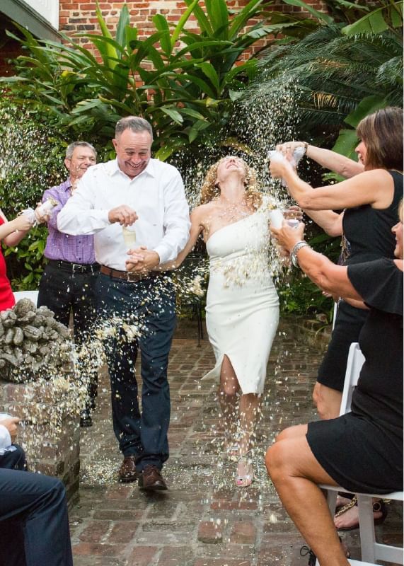 People popping Champaign in a wedding at Audubon Cottage