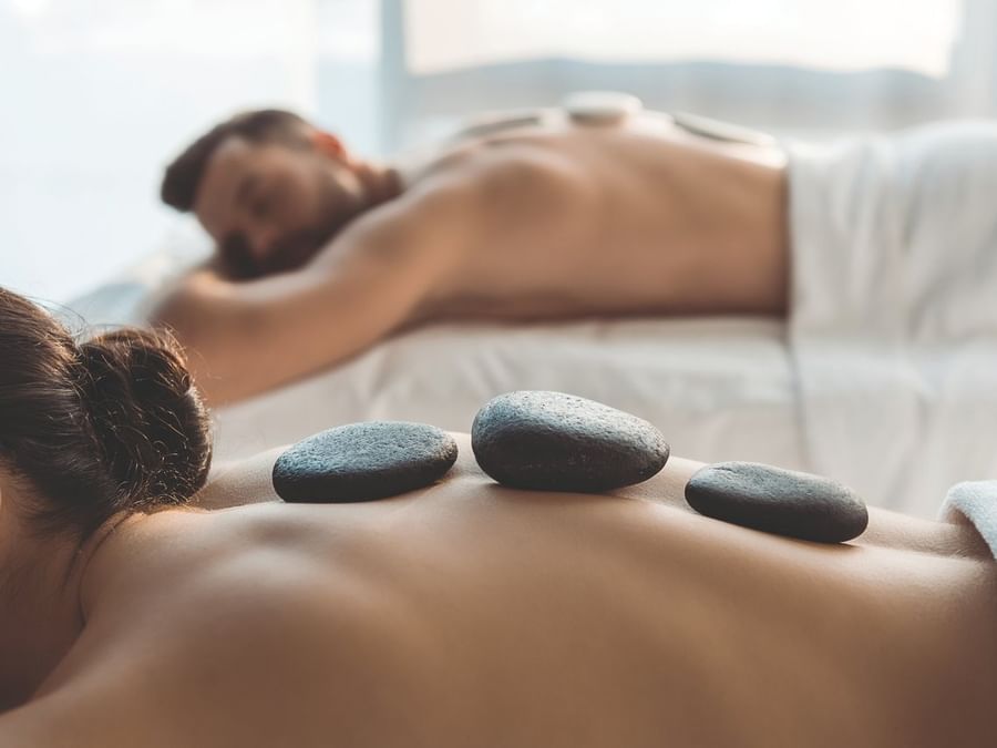 Pareja disfrutando un relajante masaje con piedras calientes en Spa Funeeq Punta Cana de Fiesta Americana Funeeq